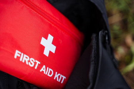 first aid kit and snacks styled, first aid and food supplies on grass, first aid pouch alongside snack bag in outdoor scene, scene displays first aid kit and snacks on grass for outdoorの写真素材