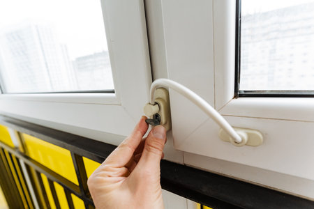 residents perform quick safety inspection on window lock during morning hours in urban apartment