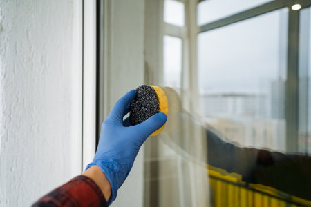 wiping window with sponge and glove, preparing interior window for clear view and aesthetic appealの写真素材