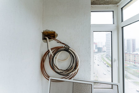 coiled balcony cable overlooking city skyline alongside renovationの写真素材