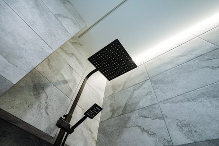 black plumbing, shower cabin bottom view, black rain shower in the bathroom, ceiling lighting in the toilet. High quality photoの写真素材