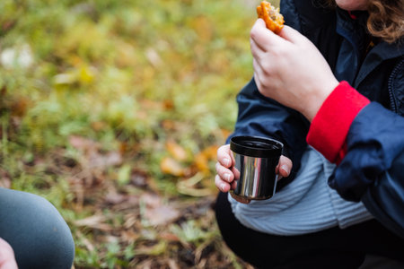 hiker outdoors snack, hiker having outdoor snack on grassy field, whiteclad hiker taking snack break in nature, person dressed for hiking enjoying meal during outdoor adventure on grassyの写真素材