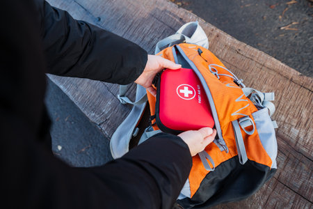 Family trip safety supplies ready, Adult preparing essential medical supplies for outdoor excursion,...