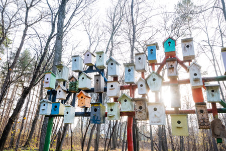 silent dawn setting featuring decorated birdhouses on poles amidst winter woodland landscapeの写真素材