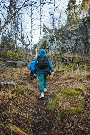 Traveler ascends rugged hillside accurately, Adventurer navigates challenging rocky ascent skillfully, Wilderness explorer steadily climbs treacherous mosscovered hillside diligentlyの写真素材
