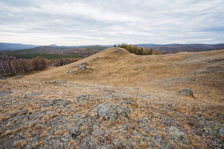 Stony mountain scenery, Majestic mountain slopes dotted with stones beneath cloudy horizons, Breathtaking rugged landscape featuring rocky hills and grand views of slopes under overcastの写真素材