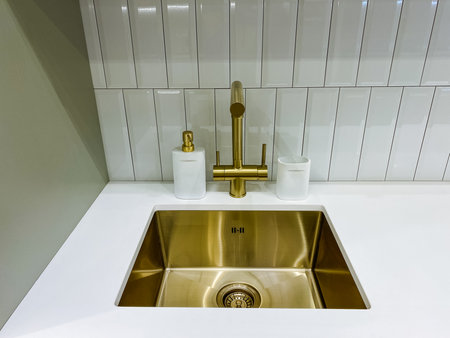 Luxurious brass faucet detail, Premium bathroom fixture showcasing gleaming metallic craftsmanship, Upscale kitchen or bathroom feature emphasizing sophisticated design and opulent materialsの写真素材