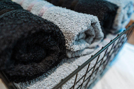 Close Up Textured Gray Towels In Basket Showcasing Plush Pile And Cotton Fibers Under Soft Light, Macro Framing Highlights Absorbent Weave And Gentle Looped Texture Ideal For Boutique Spa Or Retailの写真素材
