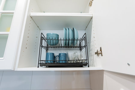 rack loaded with stacked plates and mugs in compact cabinet, highlighting efficient use of vertical...