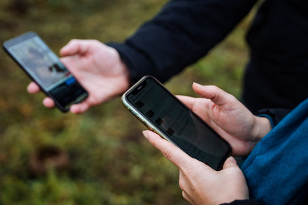 two devices examine mushroom images, inspecting fungus photos collaboratively with smartphonesの写真素材