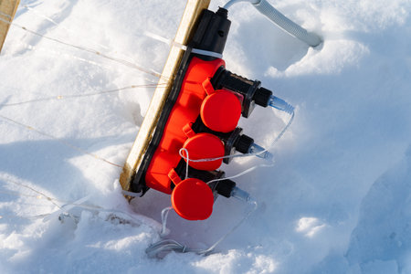 Detail Red Caps Sealing Snowy Connectors With Visible Gasket And Rubber Texture, CloseUp Focuses On Vibrant Covers, Frozen Crystals And Protective Design Emphasize Durability And ColdWeatherの写真素材