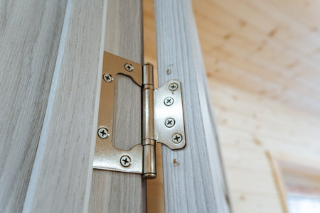 CloseUp Metal Hinge On Wooden Frame Revealing Screws And Alignment Detail, Brushed Stainless Finish,...