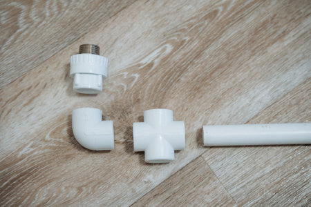 Metal To Plastic Connection On Wooden Surface. Detailed View Of Plumbing Adapter And Elbow Assembly....