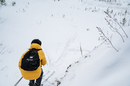 Individual Resting Amidst Icy Mountain Slopes. Lone Adventurer Takes Reflective Break In Snowy...