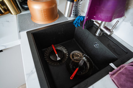 Kitchen Chores Underway. Unwashed Dishes Require Attention Now. Cluttered Area Indicates Cleaning Is In Progress. Sink Filled With Debris Shows Activity Of Tidying Up Ongoingの写真素材
