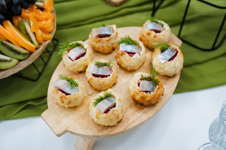 Delicious Snack Selections. Cheese Tartlets Garnished With Cucumber And Dill On Serving Paddle. Savory Treats Featuring Cucumber And Dill Cheese On Crispy Shells With Herb Cream Toppingの写真素材