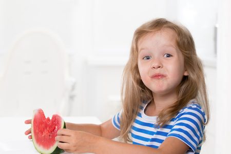 Cute kid girl eating a slice of watermelonの写真素材