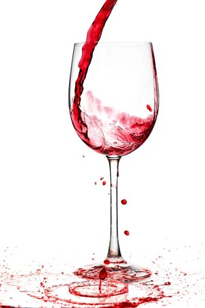 red wine being poured into a wine glass from a height の写真素材