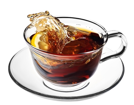 hot tea splashes as a lemon slice or sugar cube is dropped into it making a mess and splashing all overの写真素材