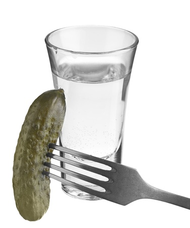 vodka in a glass and salted cucumber on a fork の写真素材
