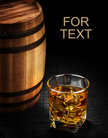 Glass of cognac on the vintage wooden barrelの写真素材