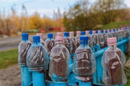 Lots of empty plastic bottles are strung on the fenceの写真素材