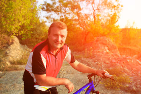 Man riding a bicycle in nature on sunsetの写真素材