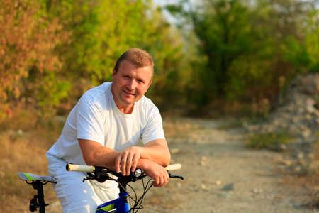 Man riding a bicycle in nature on sunsetの写真素材