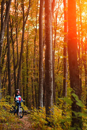 Female tourist and bicycle enjoying wood viewの写真素材