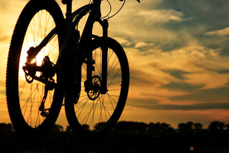 bicycle on a road against sunset. travel conceptの写真素材