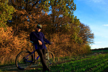 Cyclist Riding the Bike on the Beautiful Autumn Sceneの写真素材