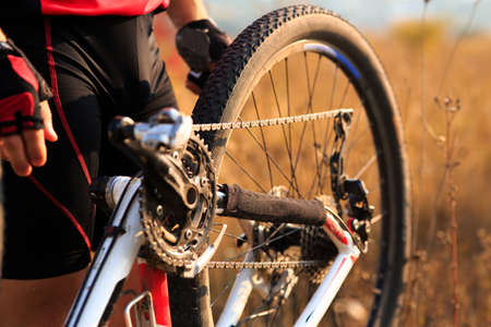 Bike repair. Young man repairing mountain bike in the forest