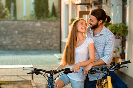 Portrait of happy young couple of bicyclists talking in the streetの写真素材