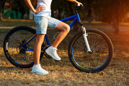 Urban biking - smiling teenage girl with bike in the city park