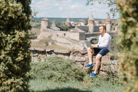 Attractive man working in your home garden. Young man working talking with smart phone in outdoors.