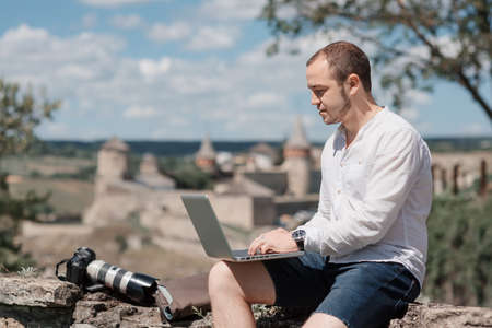 Work and relax. smiling Businessman working with laptop at the park cafeの写真素材