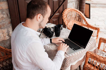 Man is looking at laptop with excitement. Photographer is choosing photos from a shootの写真素材