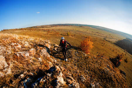 Fisheye of cyclist standing with mountain bike at sunrise against ...