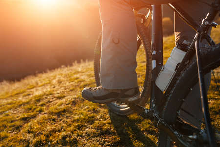 Closeup of cyclist man legs riding mountain bike on outdoor trail in natureの写真素材