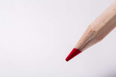 red pencil draws or writing on white paper sheetの写真素材