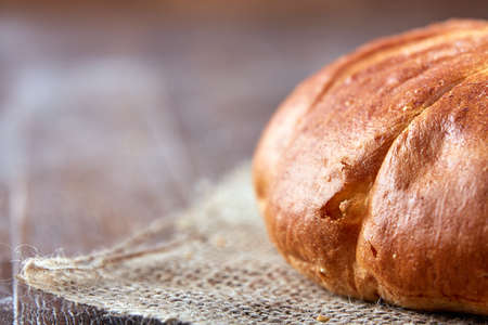 one loaf of bread close-up on a brown background. close-up with blur and macro.