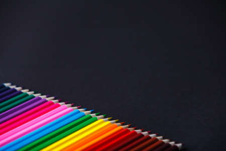 Color wooden bright pencils shades range on a dark background. Angle. Tips of the pencils. Place for the text. Concept. Art and design. Drawing and painting. Artist.の写真素材