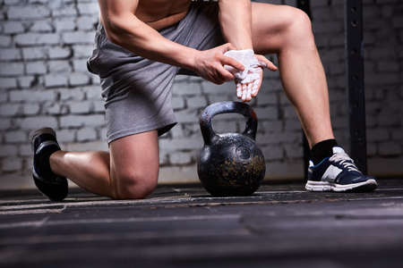 Close-up photo of young athlete man getting ready for crossfit training against brick wall.の写真素材