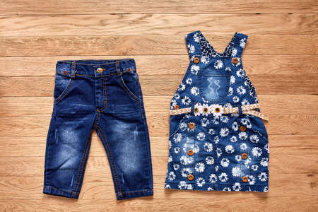 Childrens jeans denim dress on wooden background.の写真素材