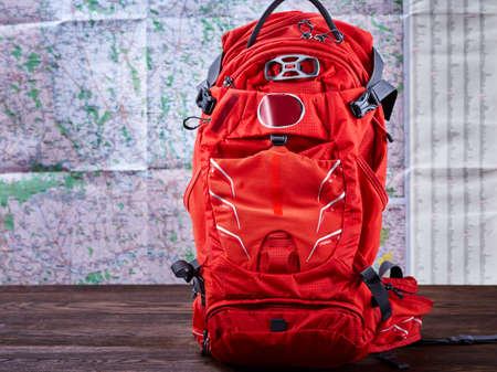 Big tourist orange backpack against map background.の写真素材