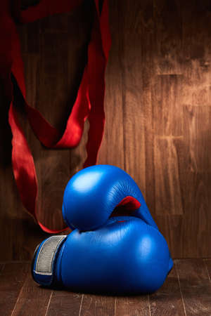 Boxing background with gloves and red bandage against wooden background.の写真素材