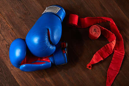 Top view of blue and red boxing gloves and bandage on wooden plank background.の写真素材