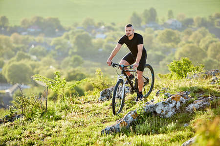 Extreme mountain cyclist riding bike on rocky trail in the countryside.の写真素材