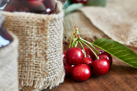 Cherry jam on wooden background in the jarsの写真素材