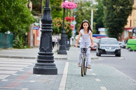 Cute kid in safety helmet biking outdoors. Little girl on a red bicycle Healthy preschool children summer activity.の写真素材